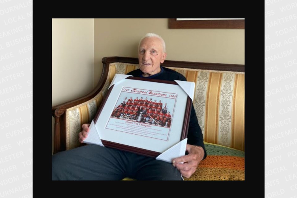 In this file photo from June 2021, Paul Masnick holds a portrait of the 1953 Montreal Canadiens Stanley Cup champions. 