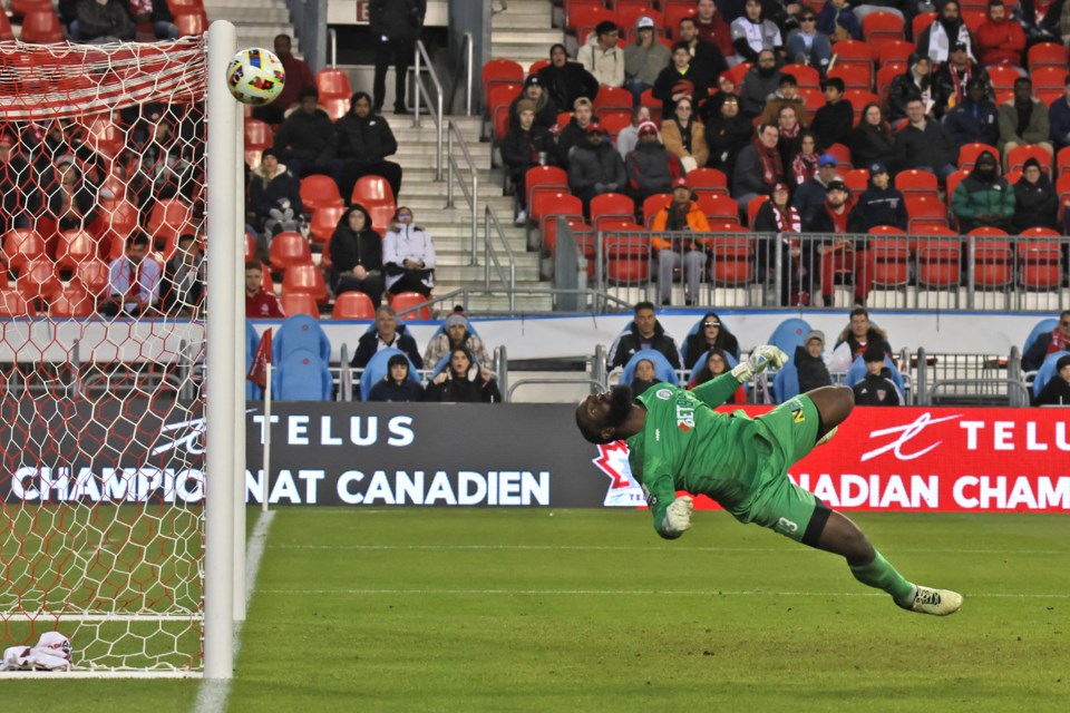 Simcoe County Rovers goalkeeper Oluwarimildalare Olatunji deflects a ball by the goalpost in the first half. Toronto FC won the game 5-0.