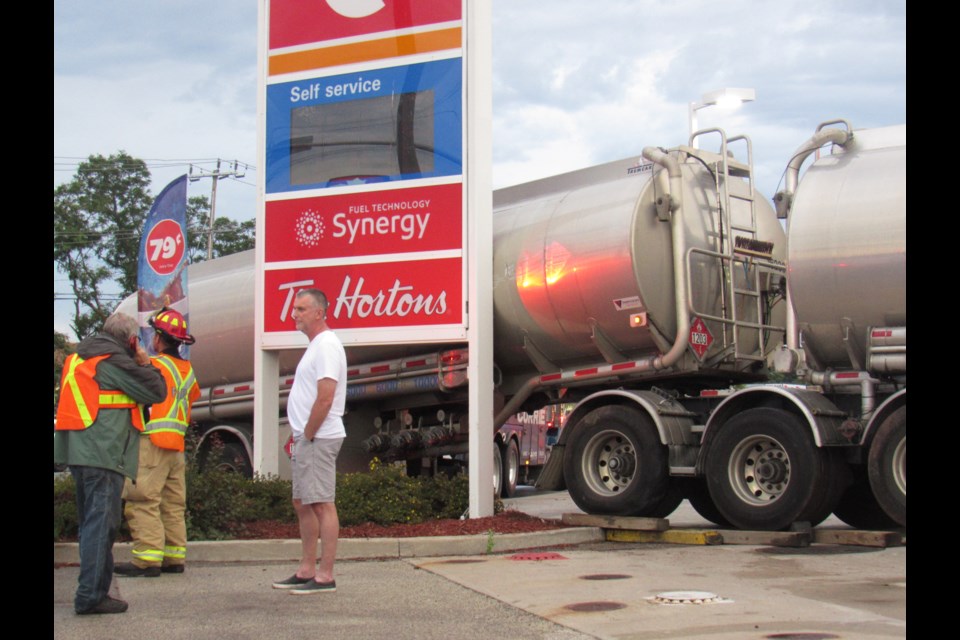 Workers wait for more crews to arrive to assist with the removal of tanker that had crashed into a gas station sign in Barrie's north end on Monday, July 29, 2019. Shawn Gibson/BarrieToday
