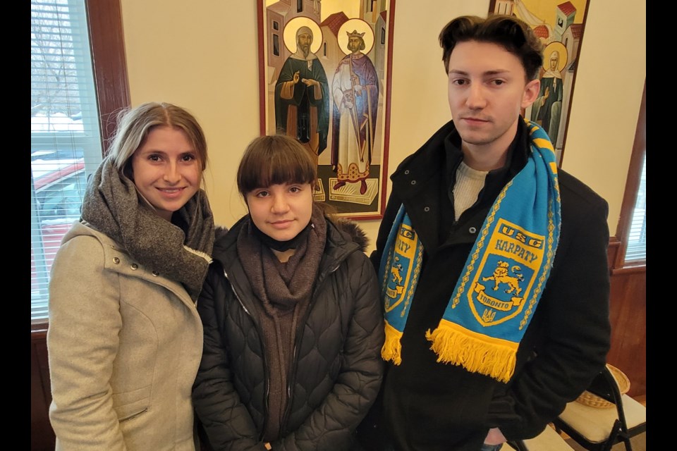 From left, Christina Jmourko (19), Iryna Spivak (13), Andre Jmourko (22) are shown at Sunday's church service.