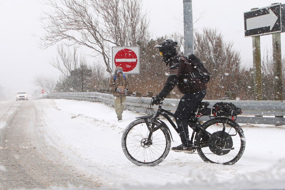 Life continues on as somewhat normal as a cyclist fights through thick slush on Bayfield street in Barrie during an ice storm on Saturday, April 14, 2018. Kevin Lamb for BarrieToday.