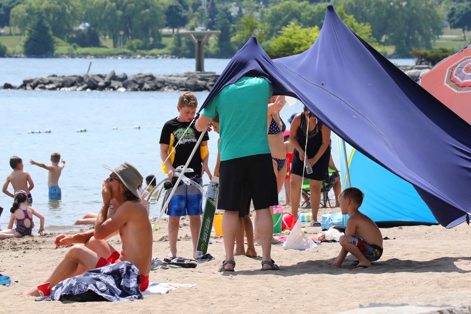 Beach-goers scramble to put up some artificial shade at Centennial Beach during the scorching heat in this file photo. Kevin Lamb for BarrieToday