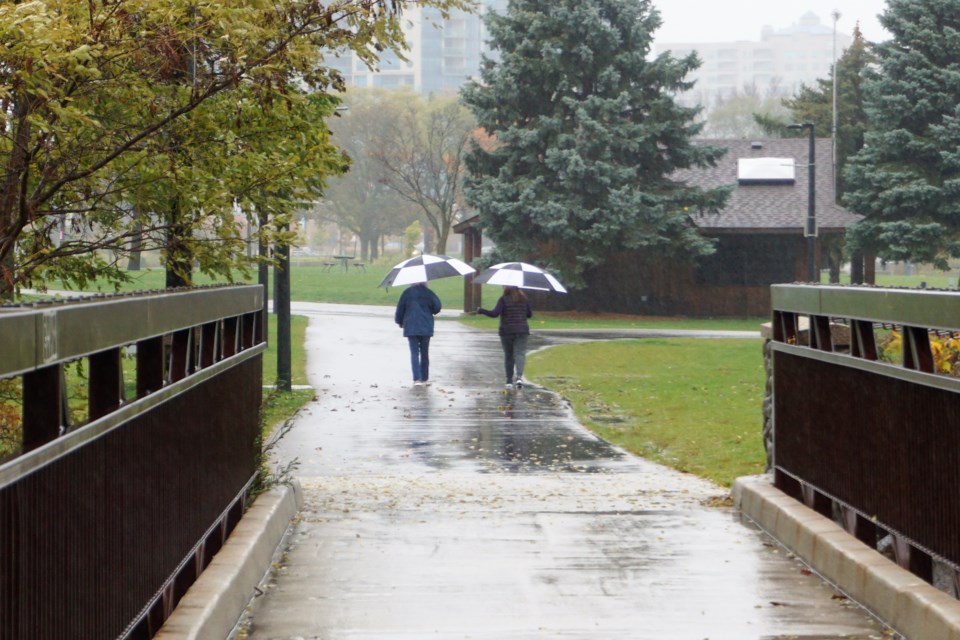 Two walkers stayed dry under umbrellas on Lakeshore Drive Sunday morning. Jessica Owen/BarrieToday