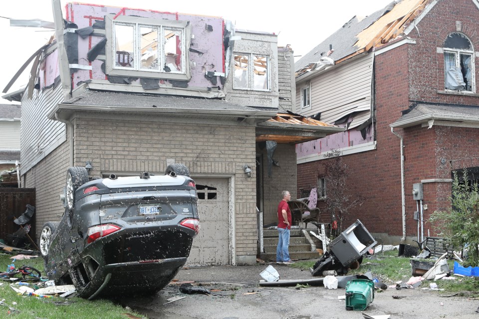 A resident surveys the damage following a tornado in the city's south end on July 15. 