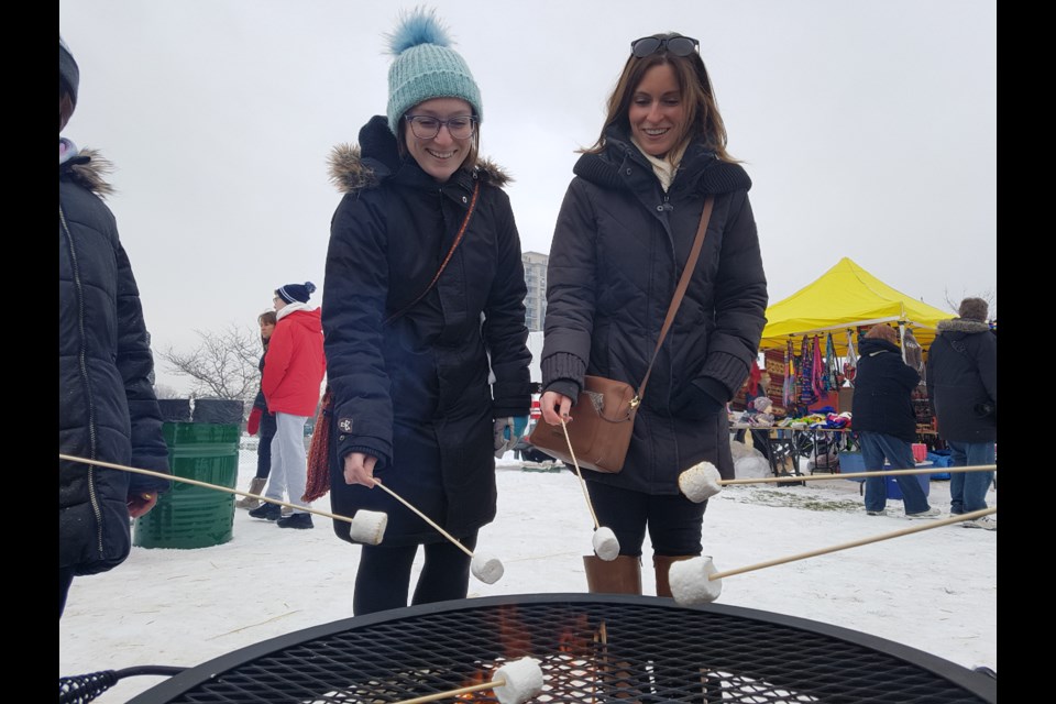 Cassandra Dell'aquila (left) and sister Alex Dell'aquila took some time to enjoy the marshmallow roasting area, Saturday. Shawn Gibson/BarrieToday