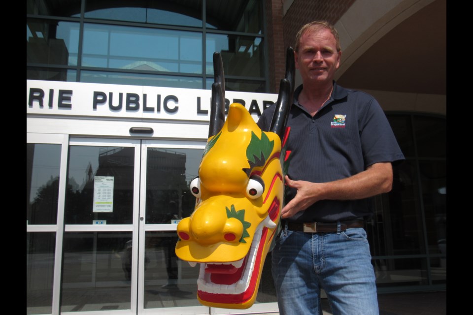 Chris Vanderkruys controls a dragon in front of the Barrie Public Library. Shawn Gibson for BarrieToday                               