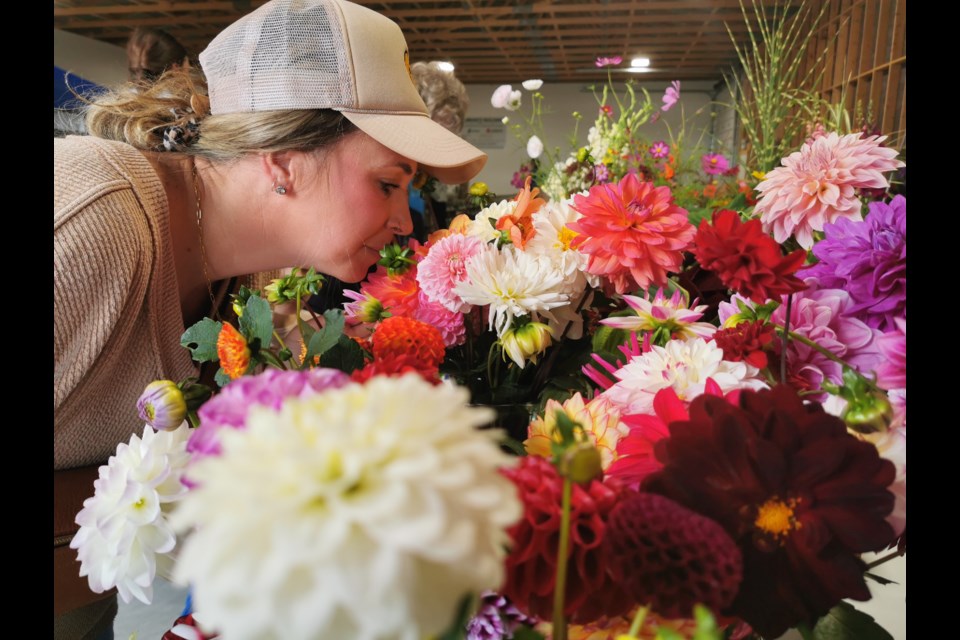 Springwater Township resident Mel Nadon takes in the fragrant aroma of a bouquet of flowers that were entered into competition at the Oro World's Fair.