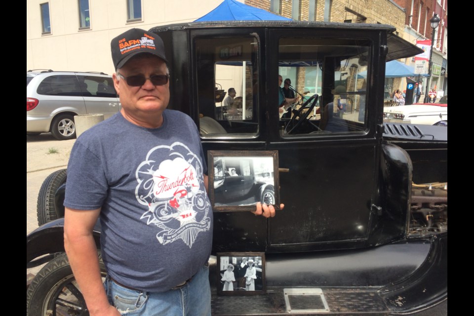 Wayne Wright holds picture of himself as a 7 year old in his father's 1924 Model T Ford