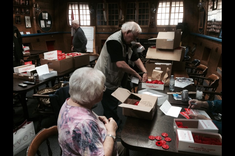 Members of West Ferris Legion Branch 599 prepare donation boxes for the annual Poppy campaign