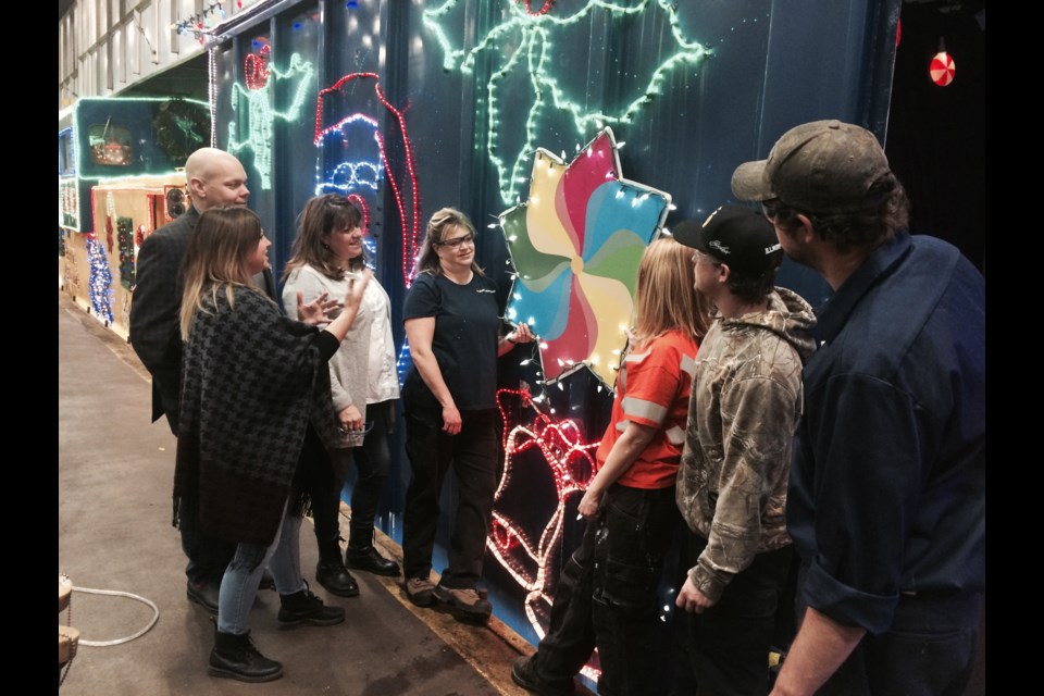 Jason Corbett and Katharine Strang of One Kids Place are shown their logo on the ONR Christmas Train by  ONR employees preparing the train for Sunday night in North Bay.