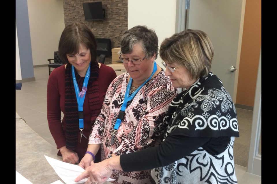 Community Living Executive Director Jennifer Valenti, receptionist Bev Phippen and Capacity Building Campaign manager Darlene Brooks go over some paperwork at their new building on Wallace Road.
