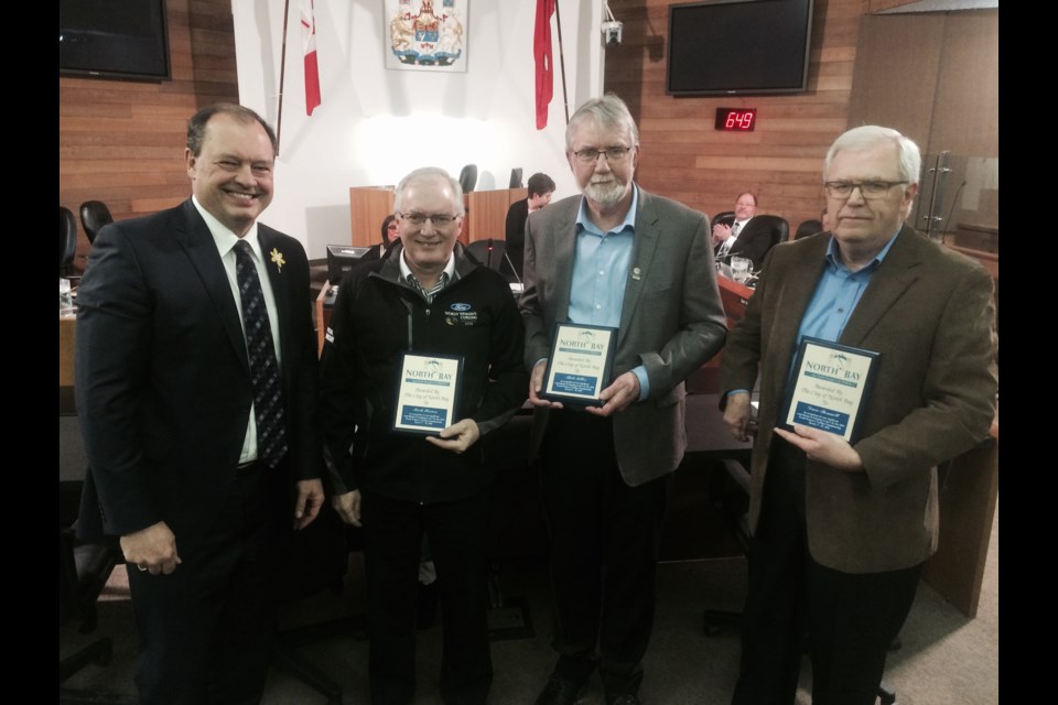 North Bay Mayor Al McDonald presents appreciation plaques to World Women's Curling vice-chairs Mark Brown, Rick Miller and Dave Bennett