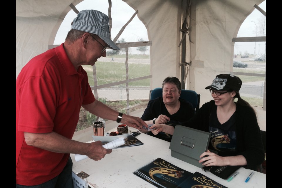 Dr. Rod Johnston purchases a copy of The Magical Midnight Rescue from Marla Hayes and Skye Hilliard
