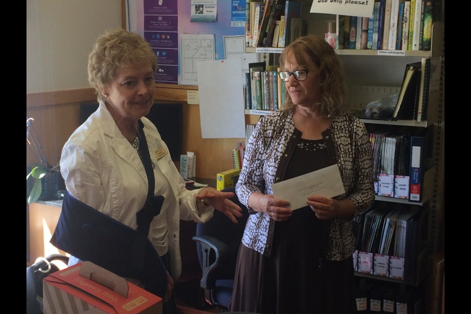 Brenda Robertson pas-president CUFW North Bay presents Helen McDonnell Callander Library CEO with $4,000 cheque 