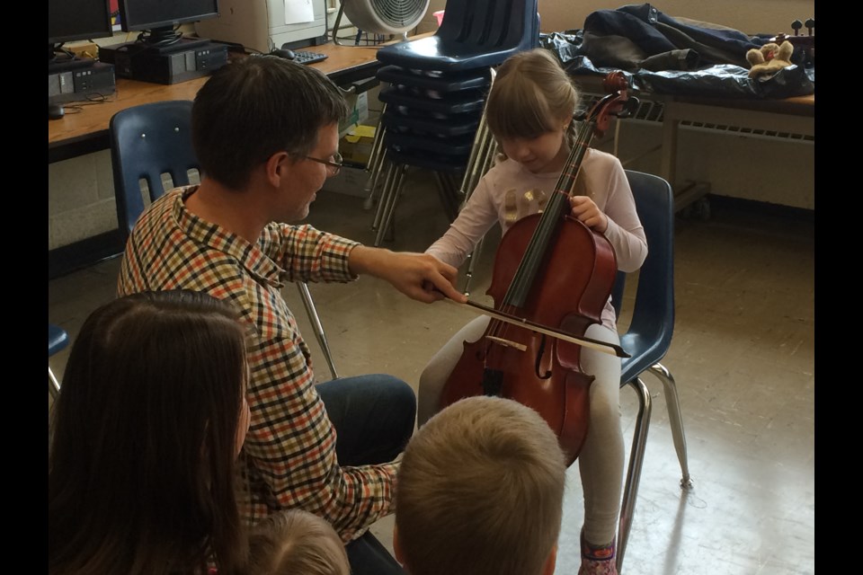 Elizabeth McMartin tries her hand playing a cello at the Learning Together event