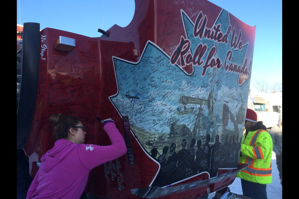 Nikita Bond.adds her to the collection of signatures left by supportes of the United We Roll Convoy for Canada