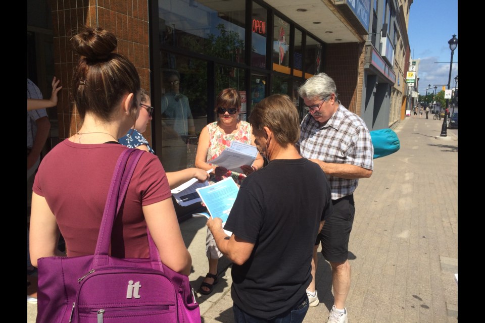 Small group gathered outside Nipissing MPP Vic Fedeli's constituency office supporting legal clinic's Day of Action