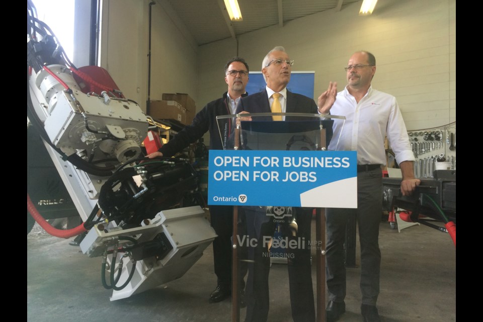 Nipissing MPP Vic Fedeli announces over $2.3 million in Northern Ontario Heritage Funding for local businesses at Drillco Mining. l-David Jones Drillco representative and r- Sylvain Bisson company president.