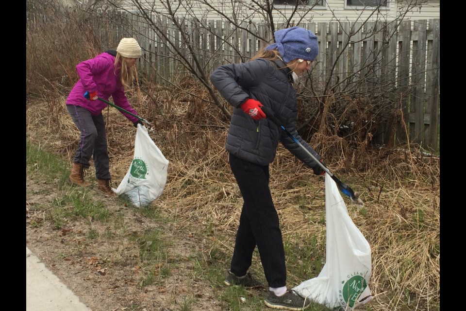 Pippa and Fiona Madigan pitch in to clean up a section of Laurentian Avenue