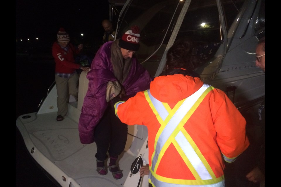 Hamilton Psychiatrist Marilyn Korzekwa is helped off of a boat after her 28 km swim is called 2 km from shore due to conditions.
Photo: Linda Holmes