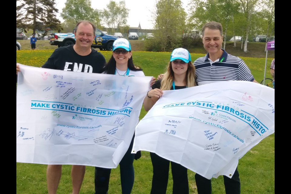 Mayor Al McDonald, CFC Social Media Manager Macrina Perron, CFC Chapter President Paige Shemilt, and MP Anthony Rota pose with banners signed by families effected by Cystic Fibrosis