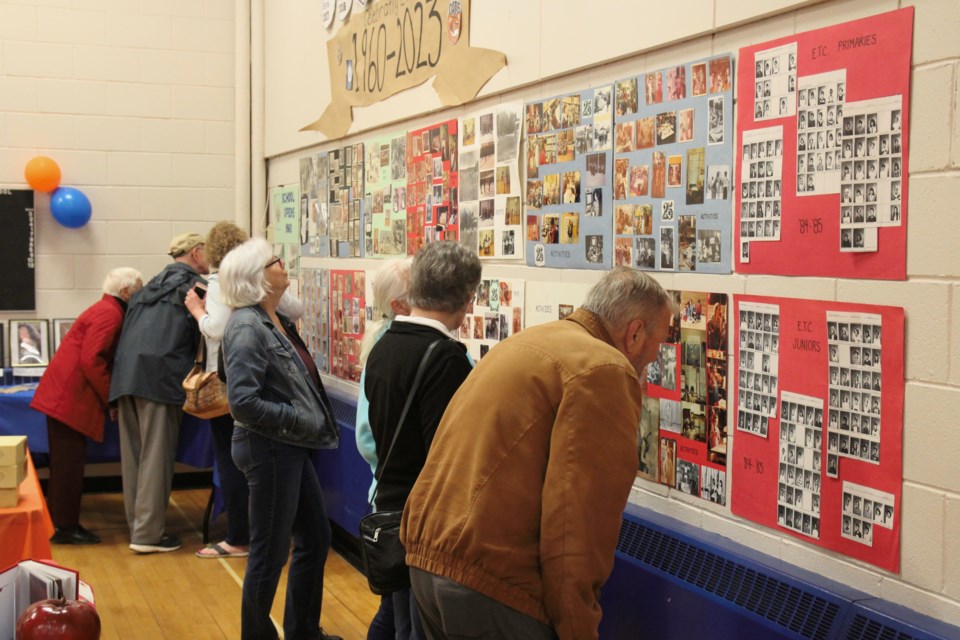 People taking into the many photos and displays at the grand farewell