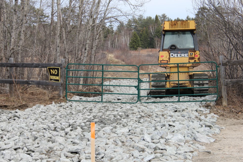 A bulldozer sits on a temporary road behind a locked gate. Jeff Turl/BayToday.