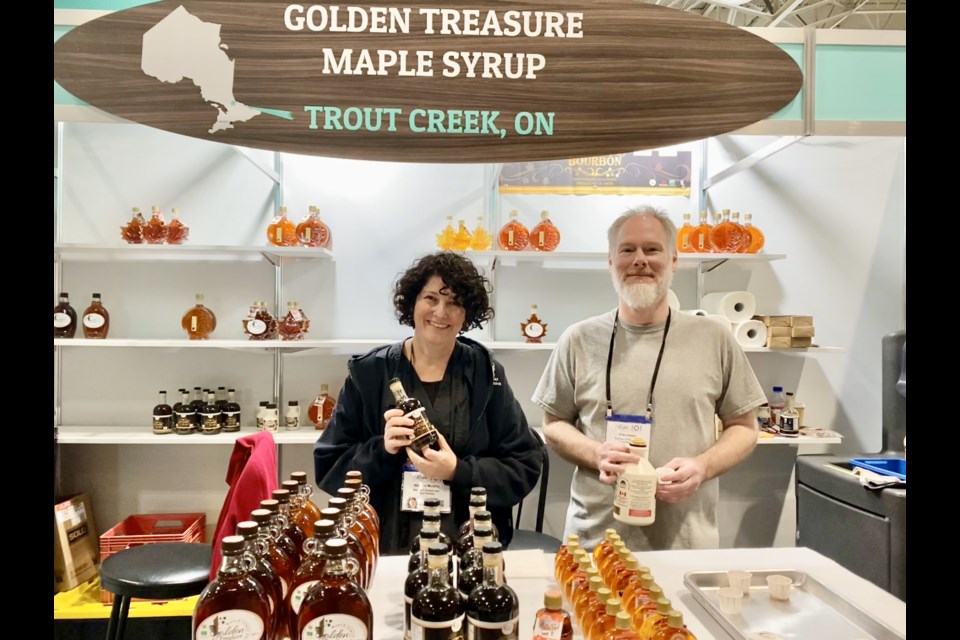 Melanie Murphy and her helper Allen Kelso promoting their business Golden Treasure Maple Syrup at the Northern Ontario Pavilion at the Royal Agricultural Winter Fair.