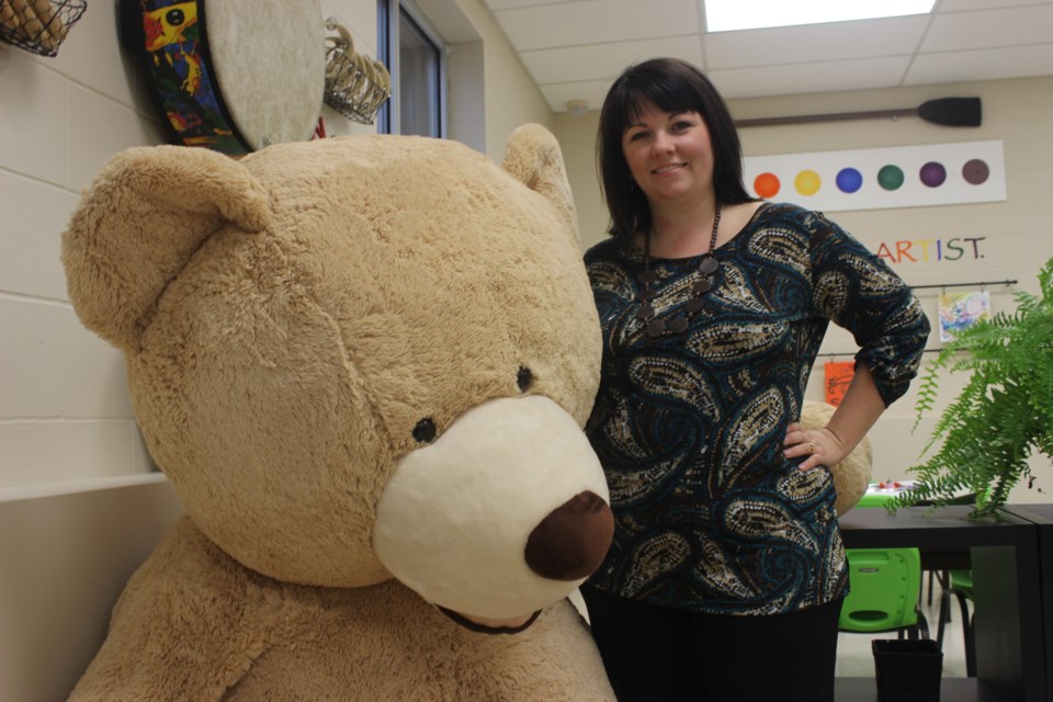 Heidi Madsen, owner and founder of Blossom Early Learning with her large stuffed bear. 