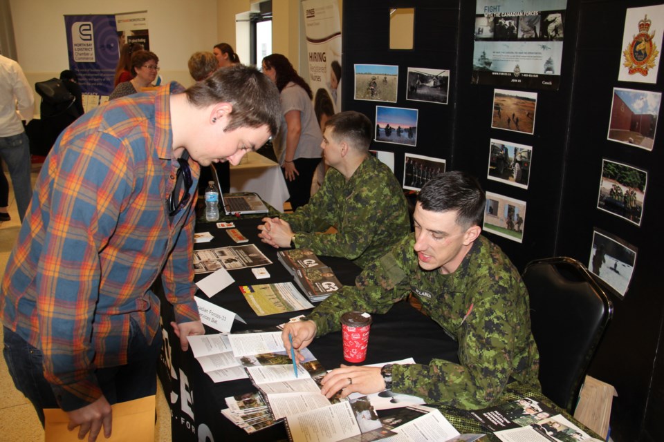 Alexandre Shank is interested in a career in the military. Here he gets advice from Sgt. Steve McLaren from the 33 Service Battalion, on what the job entails. Sgt. Phil Frazer is in the background. Photo by Jeff Turl