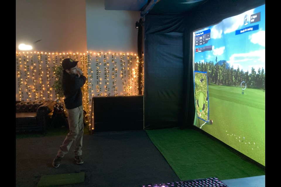Dan Conlin, Owner / Operator of The Golf Department in North Bay, takes a swing at the golf simulator. Photo by Matthew Sookram. 