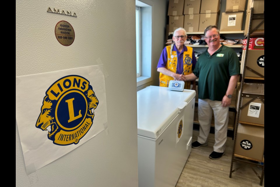 Ferris Lion's Club president Claude Beaulne and The Gathering Place's Dennis Chippa show off the new freezers that were purchased through a Lion's Club donation. 