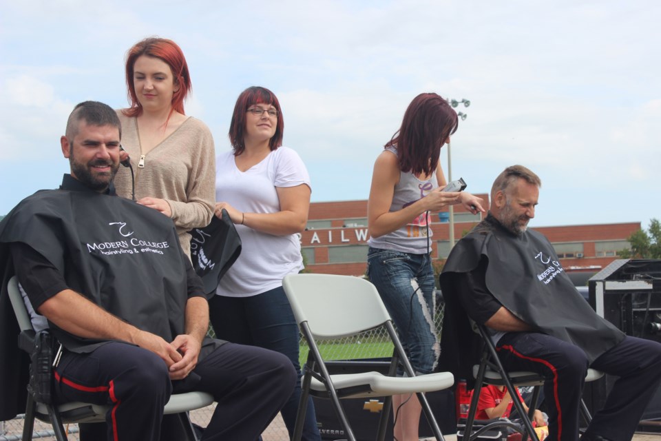 Merv Shantz (left) and Gerry Martin get buzzed 'down to the wood' as part of the Cops for Cancer fundraiser. Photo by Ryen Veldhuis.