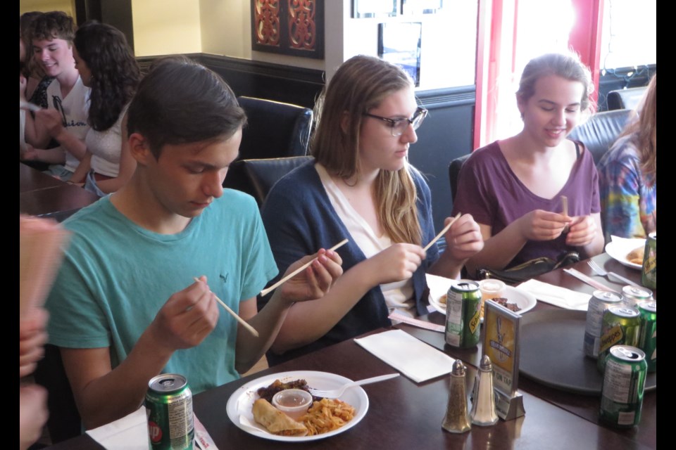 Learning to use chopsticks are students Preston Robinson, Gabrielle MacMillan, and Emily Sacher. Submitted.                 