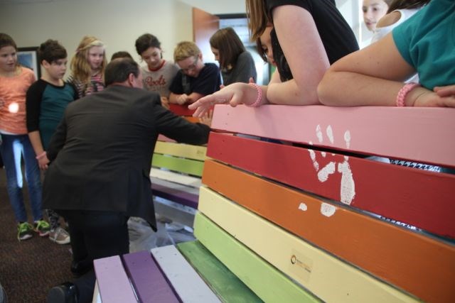 Mayor Al McDonald makes the first hand prints on the Heritage Buddy Benches. Photo by Chris Dawson. 