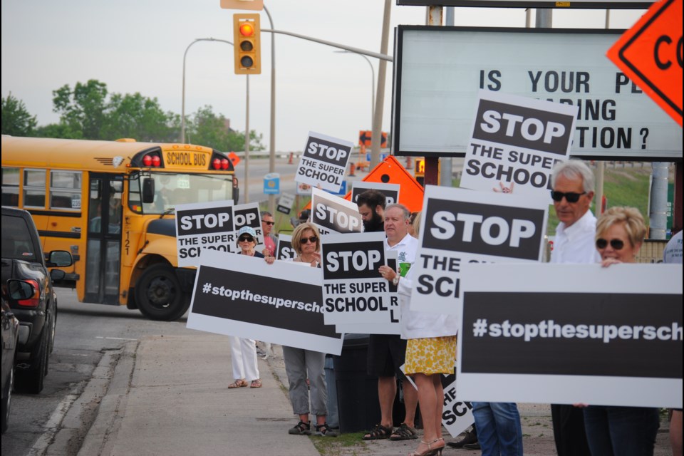 Members of the group "Stop the Super School" rallied at the Lakeshore Drive overpass Monday morning. Photo by Stu Campaigne.