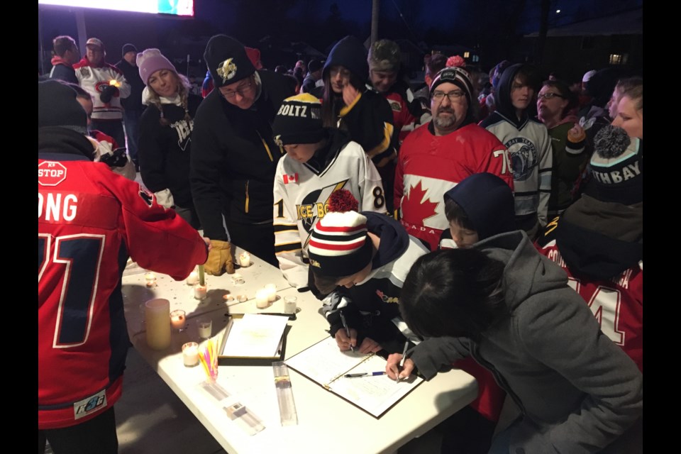 Hockey fans sign a book of condolences provided by Martyn Funeral Home.  Photo by Chris Dawson. 