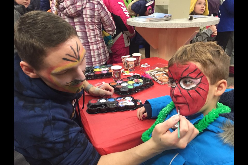 Patrick Ryan of Kirkland Lake paints a Spiderman face on Dominic Furrow, 7, of St. Vincent school. Jeff Turl/BayToday.