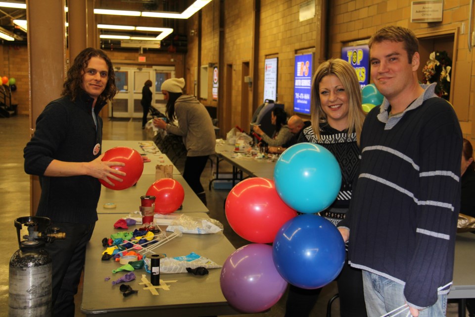 Volunteers blow up balloons in preparation for the Families First event tonight. Photo by Jeff Turl.
