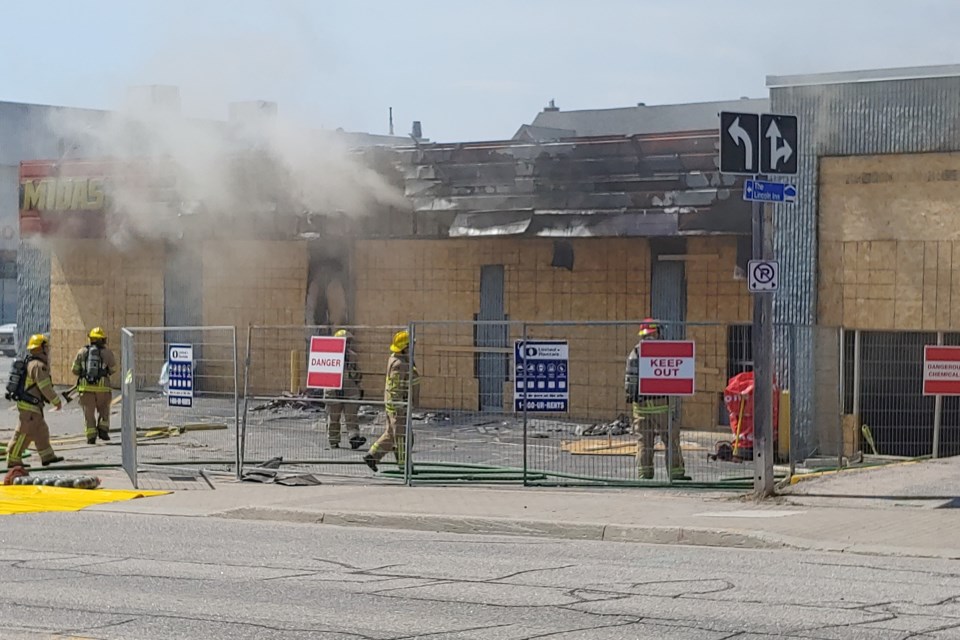 North Bay fire crews work to contain a fire at the former Midas garage on Main Street East, Monday.