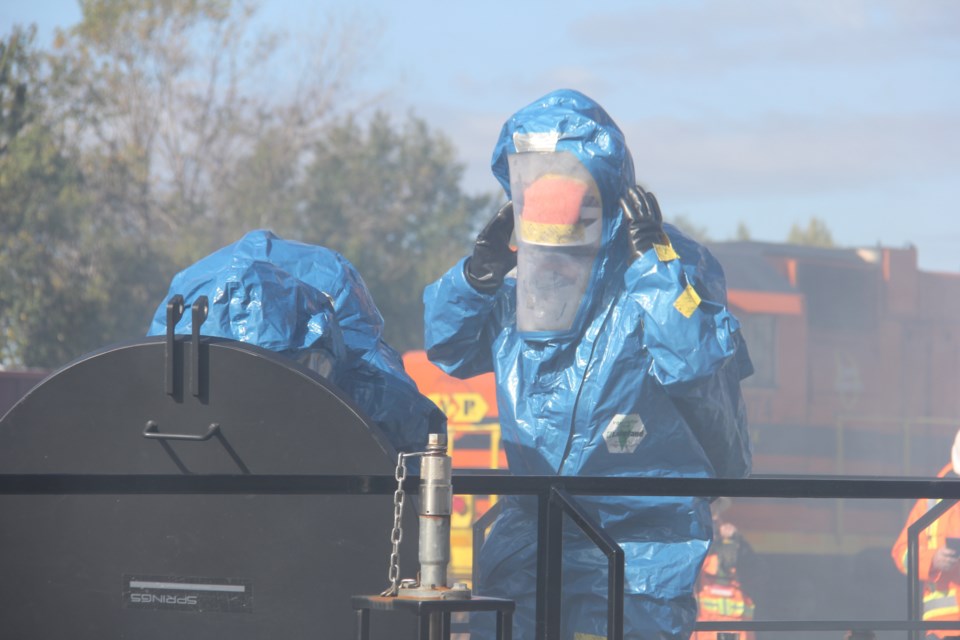 Firefighters in hazmat suits battle a simulated chemical spill at the OVR rails yard off Oak St. Fog is simulated anhydrous ammonia vapour. 