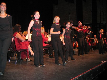 Chad Wolfe, far right, plays the fiddle as members of his dance school tap away.