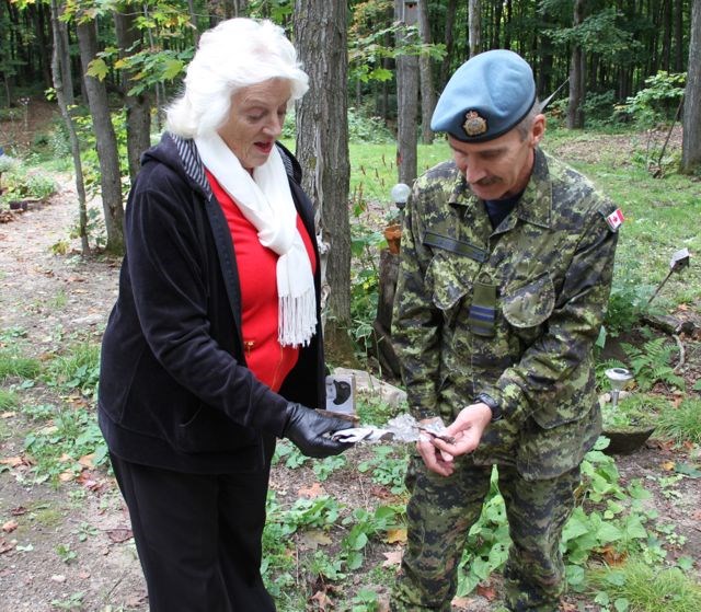 Dianne looks at a piece of metal found near the crash site. 