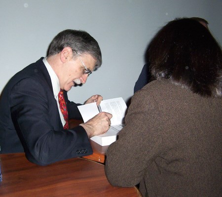 Lt-Gen. (Ret.) Romeo Dallaire signs a copy of his book at The Wall last night. Photo by Levi Perry, Special to BayToday.ca.