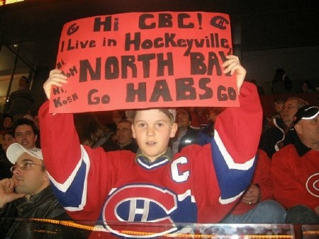 North Bay's Sean Boucher holds up a Hockeyville sign at a Montreal Canadiens home game on March 24th.  Photo submitted. 
