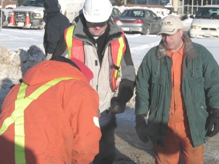 Coun. Tom Mason and Mayor Vic Fedeli watch a city employee repairing a frozen fire hydrant on McKeown Avenue,