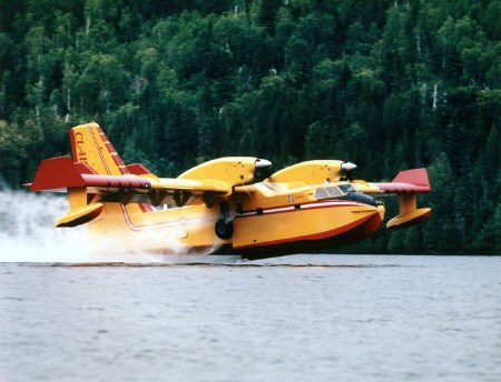 A Canadair 415 water bomber refills its belly.
