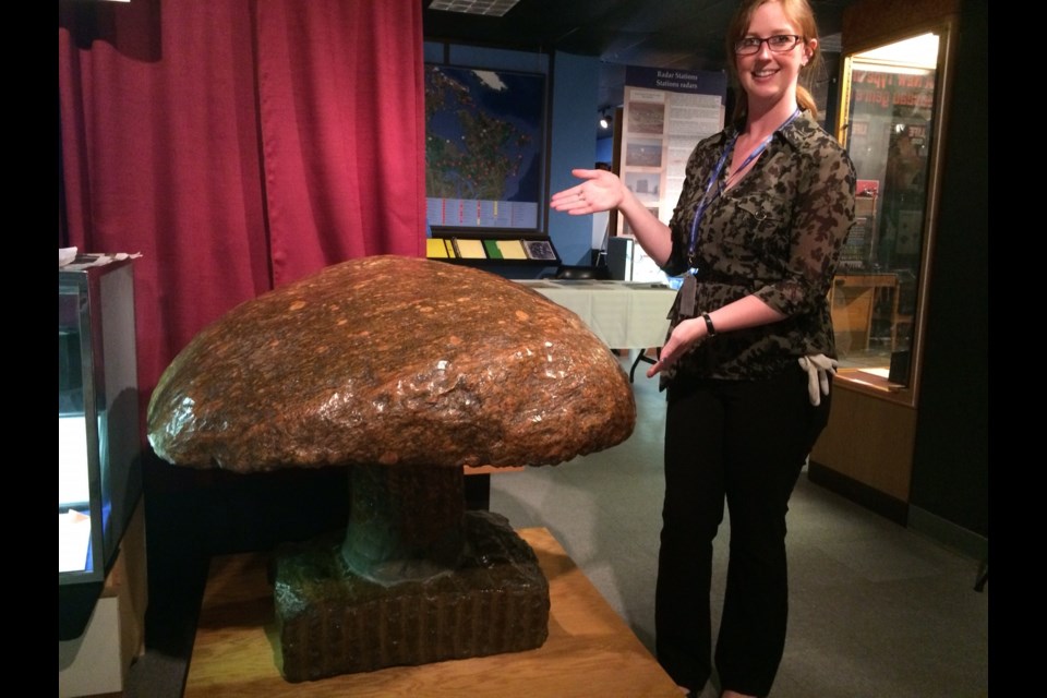 Bethany Aitchison shows of the giant granite mushroom. The mascot of NORAD workers who served in 'The Hole'. Photo by Jeff Turl.