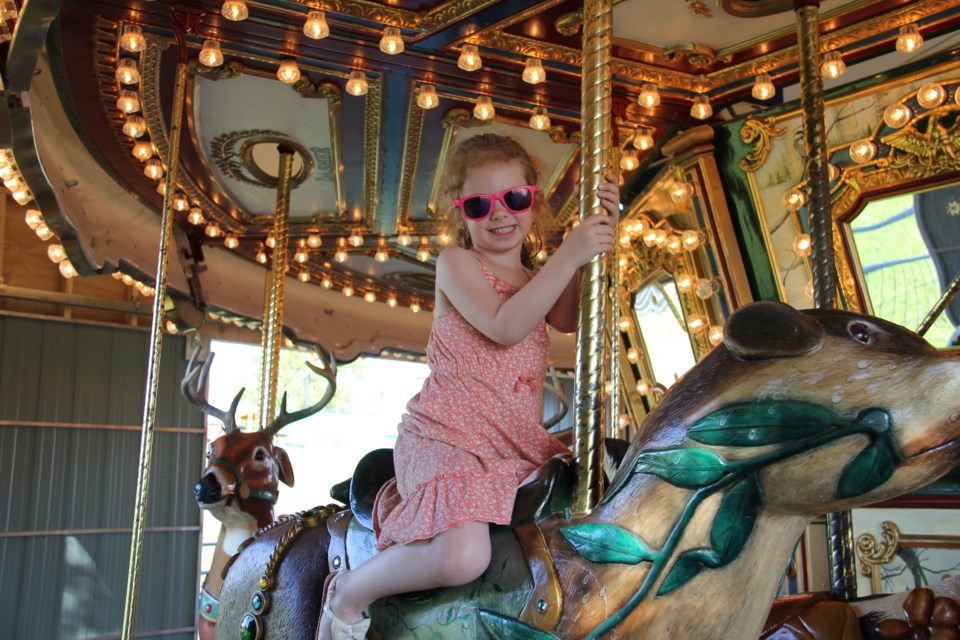 USED 170706 5 Vesper Sheridan, 4, enjoys a ride on the Winter Wonderland carousel . Photo by Brenda Turl for BayToday.