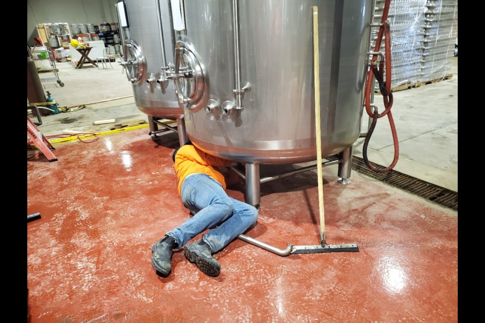 A New Ontario Brewing Company worker installs critical equipment for the making of hand sanitizer In North Bay. (Supplied photo)